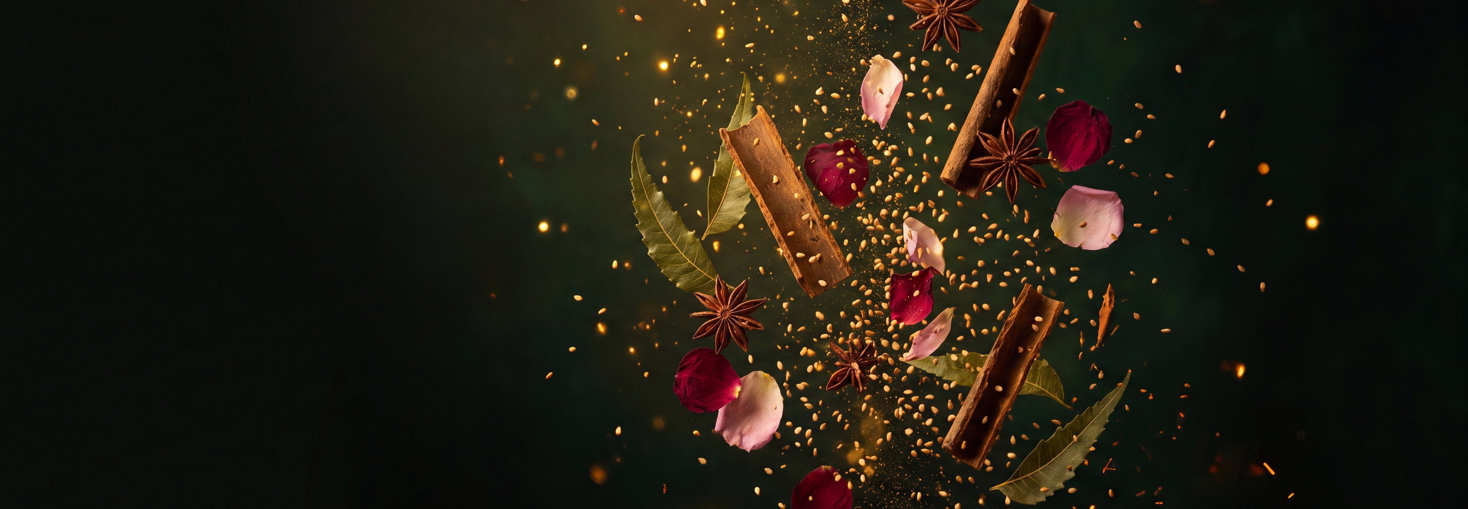 Neem leaves, cinnamon bark, star anise, rose petals and sesame seeds suspended in mid-air